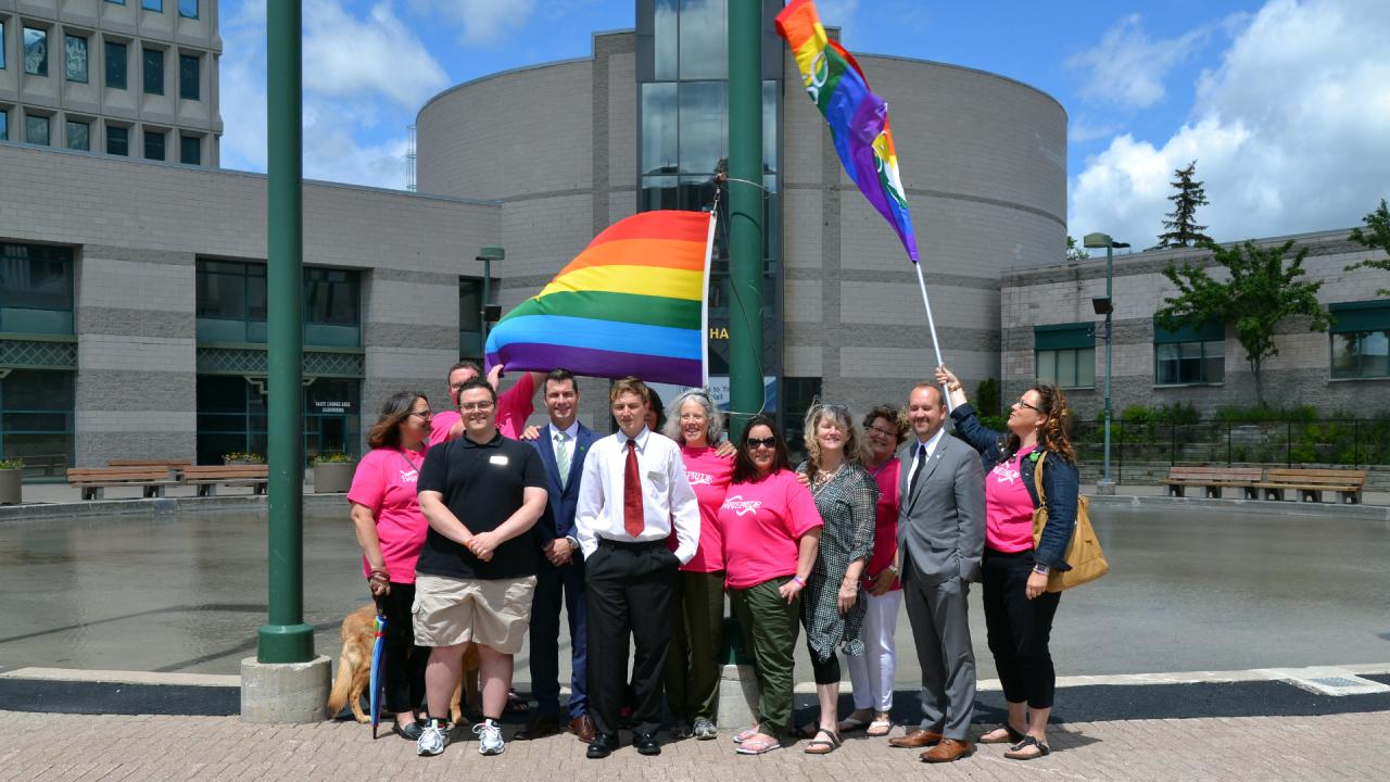 The core of Barrie Pride stood proudly beneath their flag