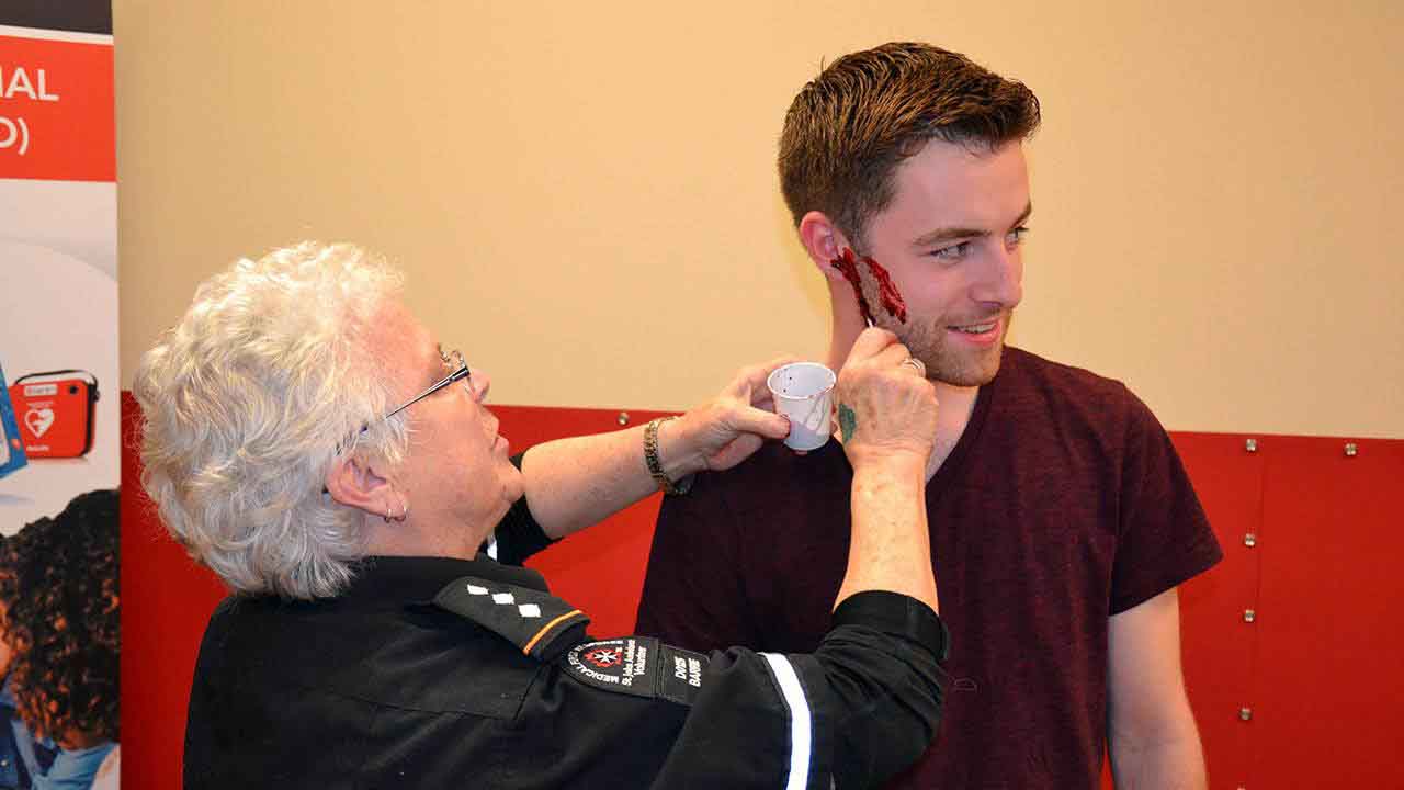 Here, volunteers are being given the Hollywood touch for our simulation . . .